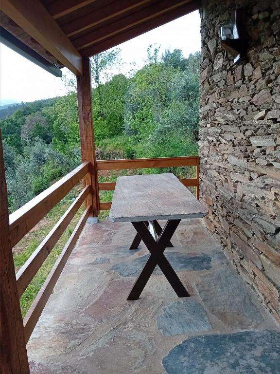 Wooden dining table on stone terrace with valley view